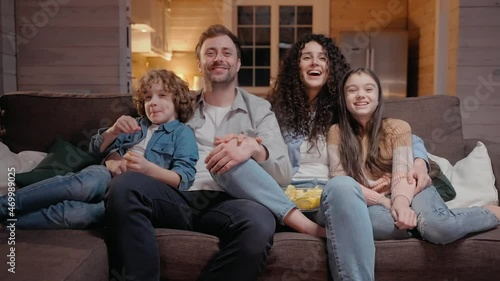 Family watching a movie together at home hugging and laughing with comedy. Family spends time together in lockdown. 50fps. High quality 4k footage