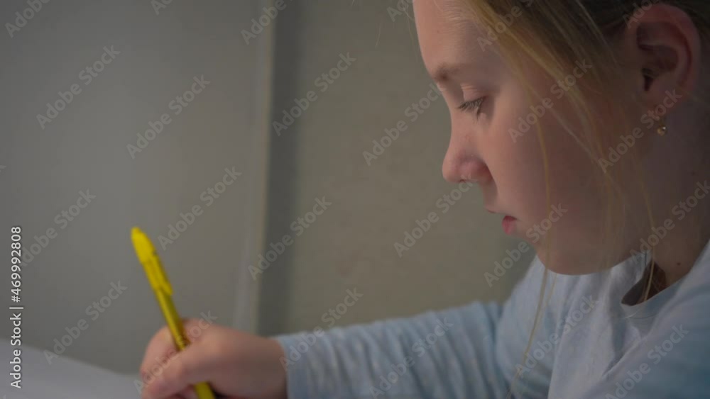 Little schoolgirl learns lessons, thoughtful child doing homework, back to school. Little schoolgirl learns lessons, thoughtful child doing homework, back to school.