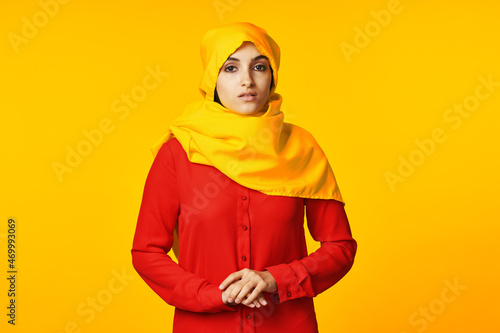 muslim woman wearing yellow hijab posing ethnicity yellow background © VICHIZH