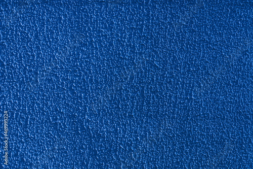 Abstract background of blue embossed rough plaster.
