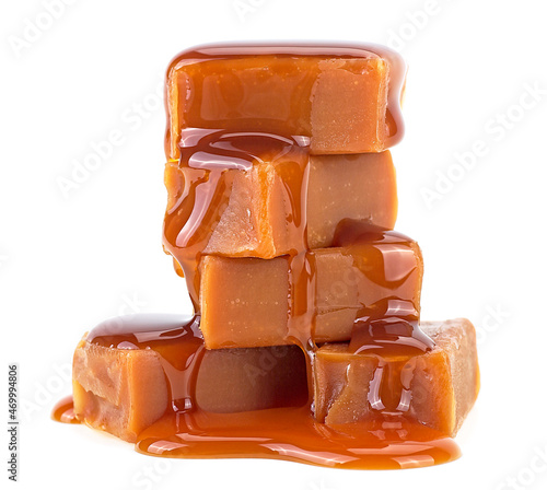Photos Sweet caramel candies with melted caramel isolated on a white background