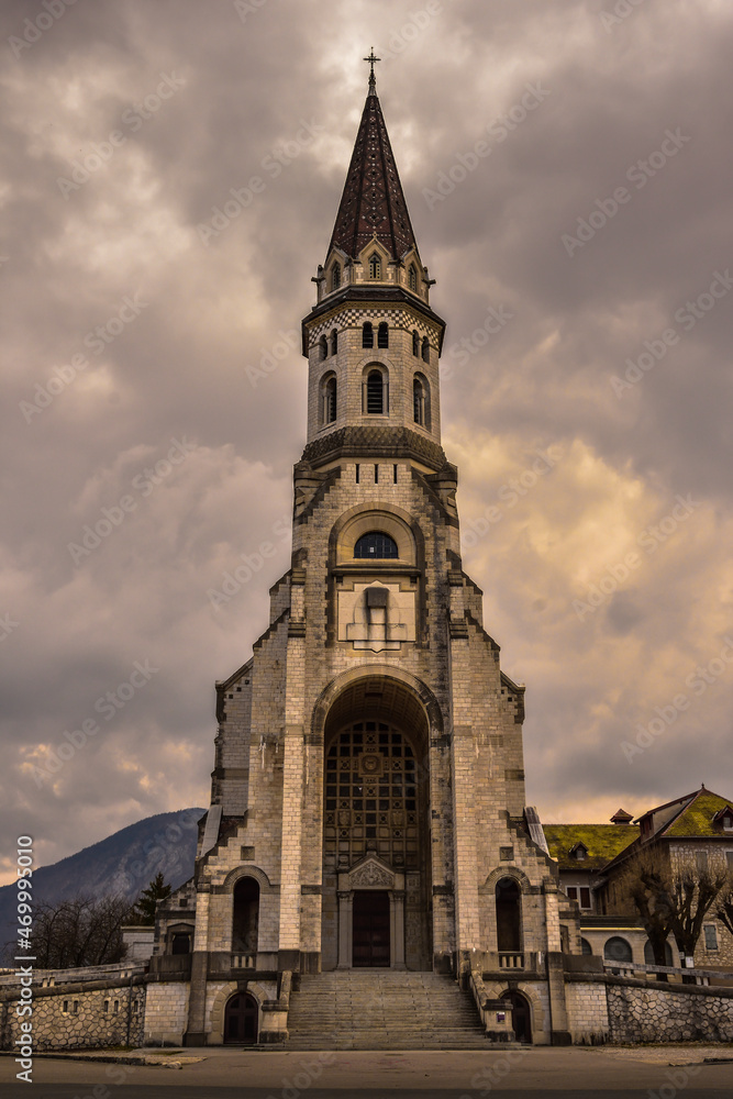 Church in Annecy, France, called Basilique de la Visitation with a dramatic sky. Symmetrical photograph.
