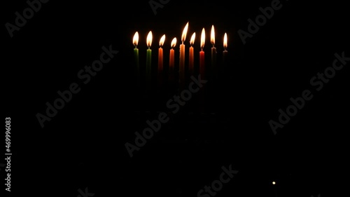 Video depicts Jewish Holiday Hanukkah with wax candles burning on menorah at night 