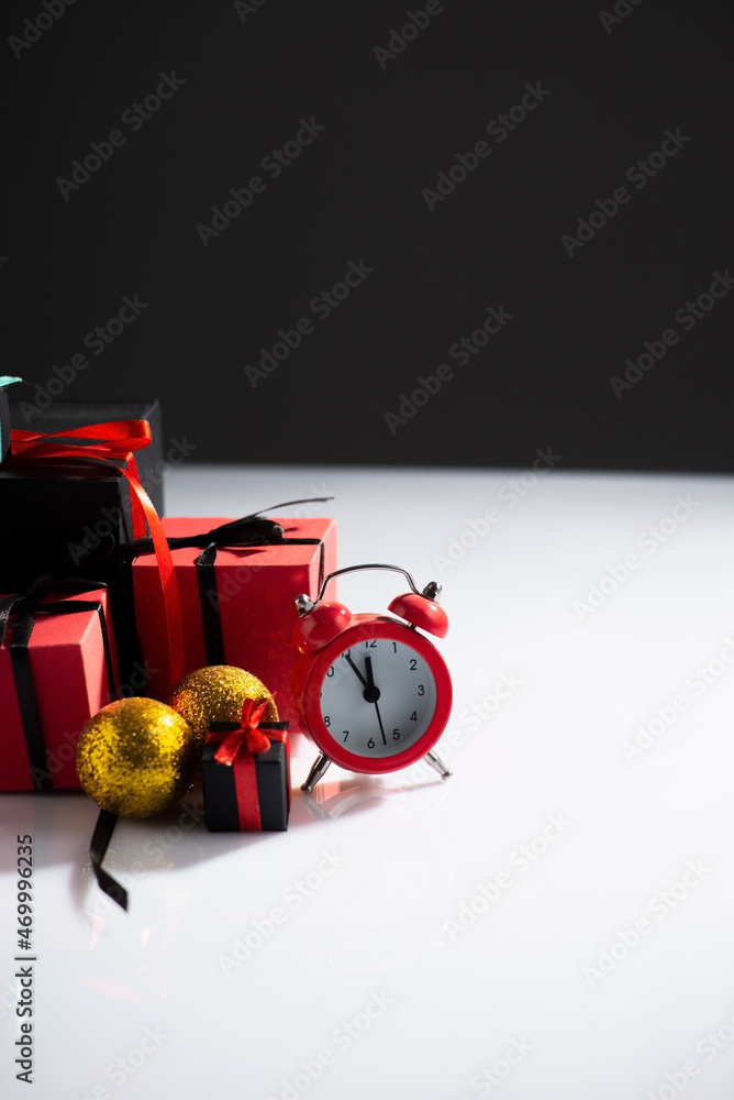 New Year's still life with watches and gifts on a white-dark background New Year's still life with watches and gifts on a white-dark background
