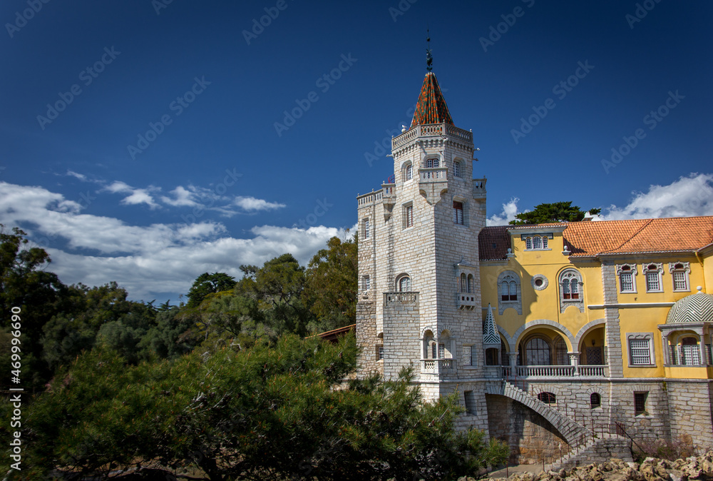  Exterior of the Saint Sebastian Tower (Torre de S.Sebastiao) museum surrounded by trees under the beautiful blue sky in Cascais, Lisbon. 
