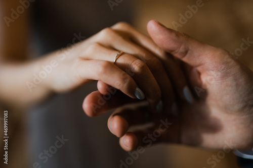 the hands of the newlyweds with rings, the groom holds the hand of the bride with a wedding ring, close-up of the hands of a couple, exchange of rings, sign of marriage proposal