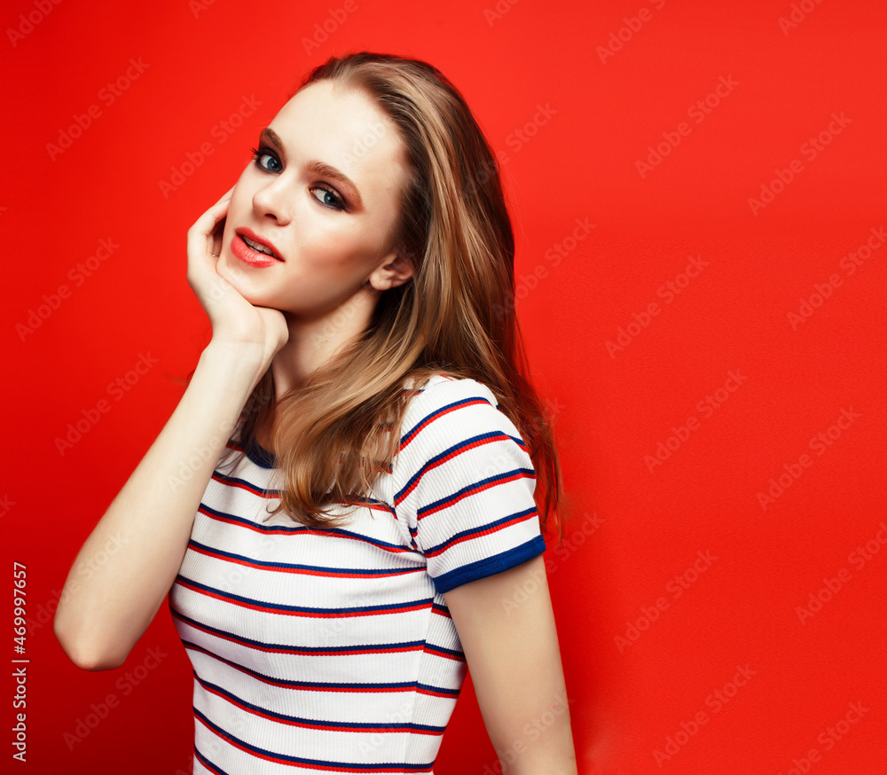 Fototapeta premium young pretty emitonal posing teenage girl on bright red background, happy smiling lifestyle people concept