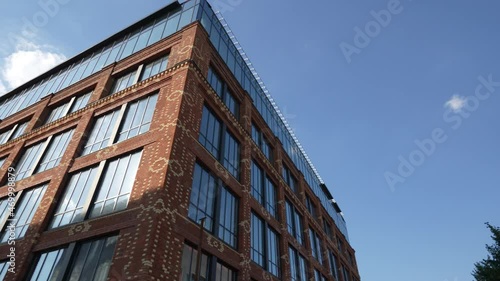 unusual brick building with panoramic large windows. bottom view. glass brick building. Shooting in motion