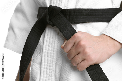 Karate coach wearing kimono and black belt on white background, closeup