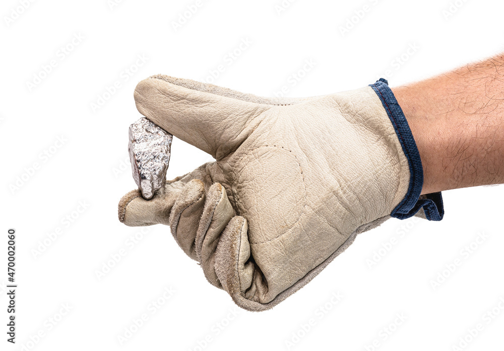 miner hand with protective glove holding silver color ore, metallic stone, isolated white background. Steelmaking or mining concept miner hand with protective glove holding silver color ore, metallic stone, isolated white background. Steelmaking or mining concept