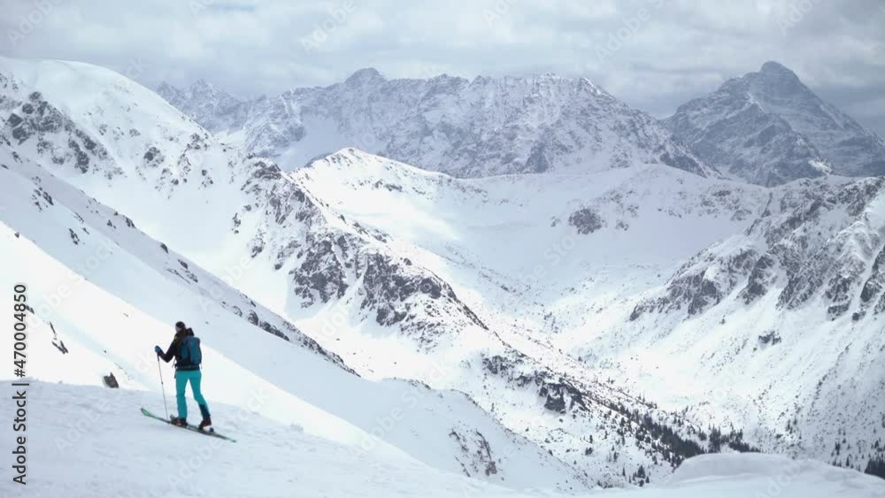 Active female tourist trekking on her skis up the snowy hill in Tatra Mountains, ski touring Active female tourist trekking on her skis up the snowy hill in Tatra Mountains, ski touring