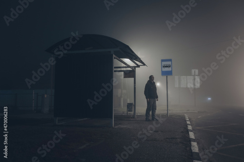 Alone sad man waiting for bus at bus stop