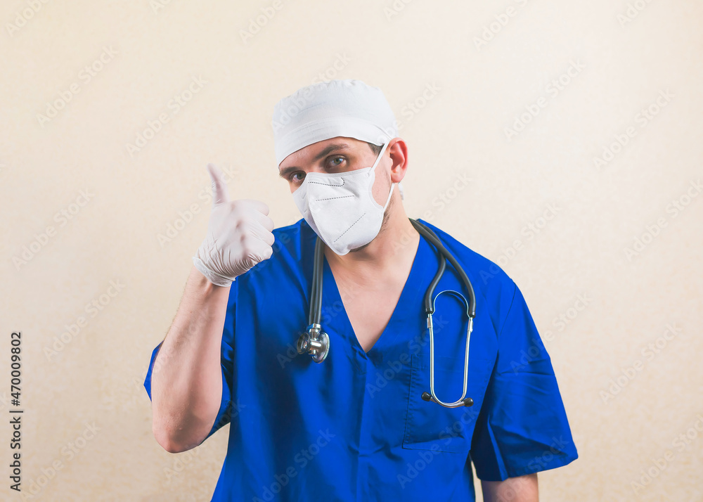Young doctor portrait with thumb up in blue surgeon suit isolated Young doctor portrait with thumb up in blue surgeon suit isolated