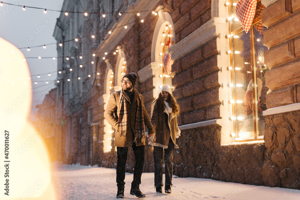 Lovely couple holding their hand in winter city at night