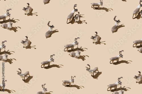 Pattern with elks isolated on a pastel beige background. Christmas and New Year celebration concept. Reindeer with antlers as announcers of the winter holiday season. Santa Claus helpers.