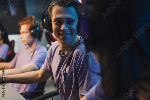 Man wearing headphones rejoicing in victory professional gamer playing online