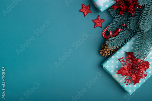 Christmas flat lay background with gifts, poinsettia and pine tree on turquoise background © Alina