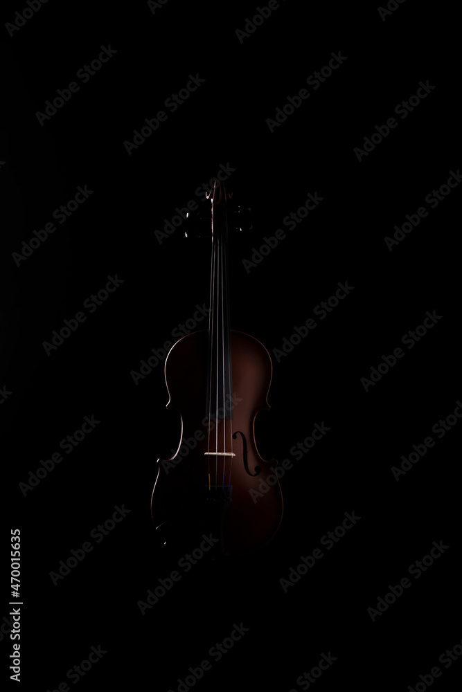 A wooden violin or viola on a black background A wooden violin or viola on a black background