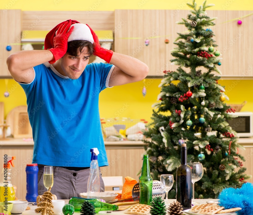 Young man cleaning kitchen after Christmas party Young man cleaning kitchen after Christmas party