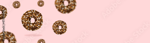 Glazed brown sweet sugar chocolate doughnut donut dessert on pink pastel background. Creative minimal blurred selective focus collage food concept