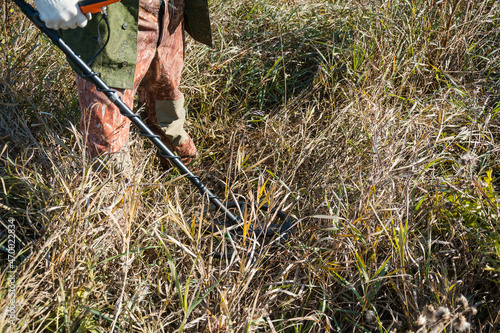 A man with a metal detector. Look for metal in the woods. Precious search engine. photo