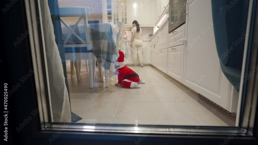 custom made wallpaper toronto digitalFamily preparing to celebrate Christmas, mother cooks food in the kitchen, baby wearing Santa Claus costume crawling on the floor, toddler playing with decoration lighting. New Year time.