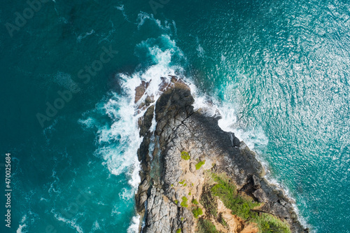 Aerial view Top down seashore big wave crashing on rock cliff Beautiful dark sea surface in sunny day summer background Amazing seascape top view seacoast at Phuket Thailand