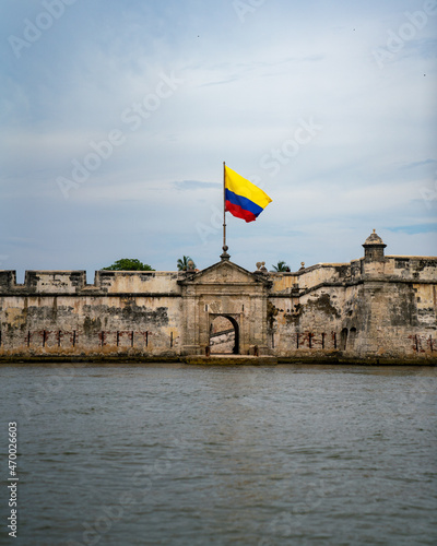 old fortress on the water with colombian flag photo