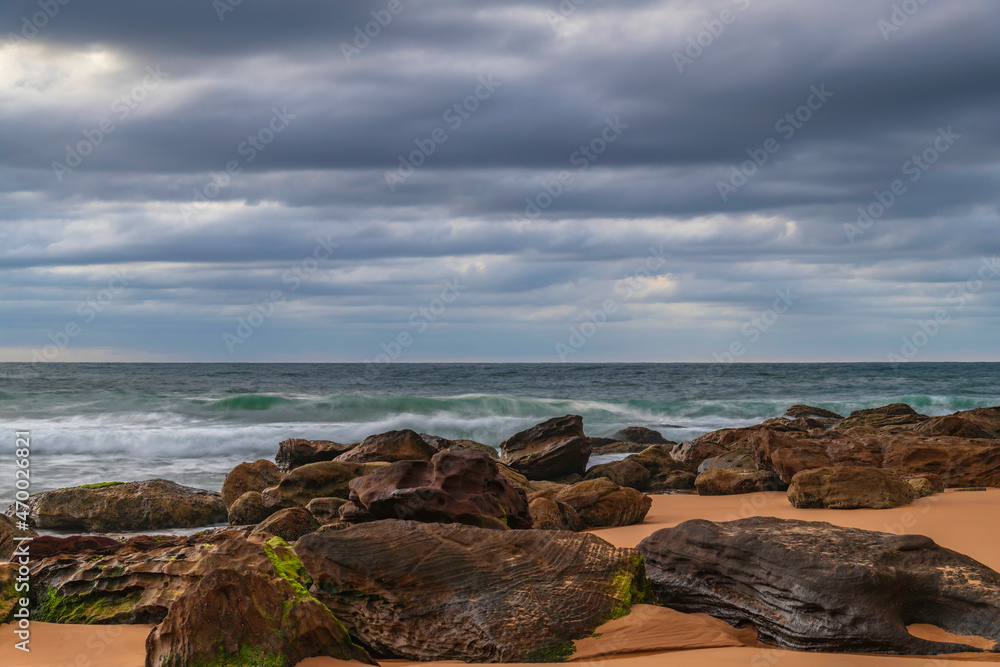 Low cloud covered sunrise seascape with rocks