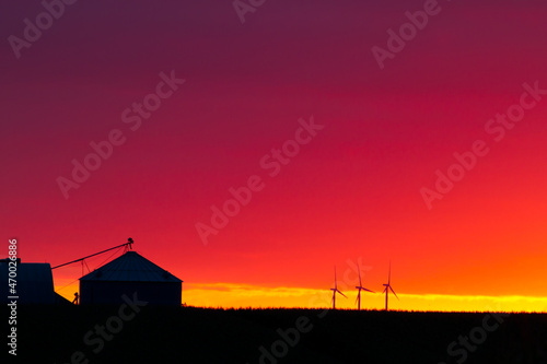 Farm buildings and windmills at sunset