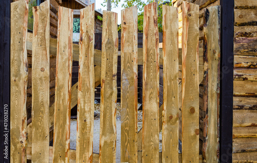 The fence is made of untreated vertical boards.