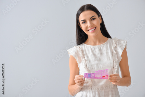 Young woman with pills in b...