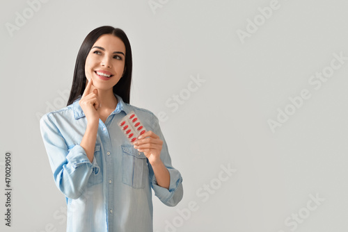 Thoughtful woman with pills...
