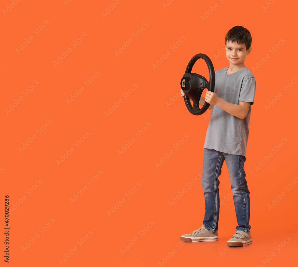 Little boy with steering wheel on color background Little boy with steering wheel on color background