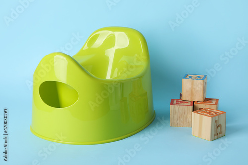 Potty and wooden cubes with letters on color background