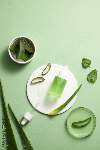 Aloe vera extract research in laboratory with a petri dish white dish dropper in light green background for aloe vera research advertising , photography science content