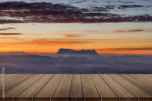 Heaven at early sunrise predawn clear sky with orange horizon and red atmosphere over the mountains with the morning mist with Empty wooden table