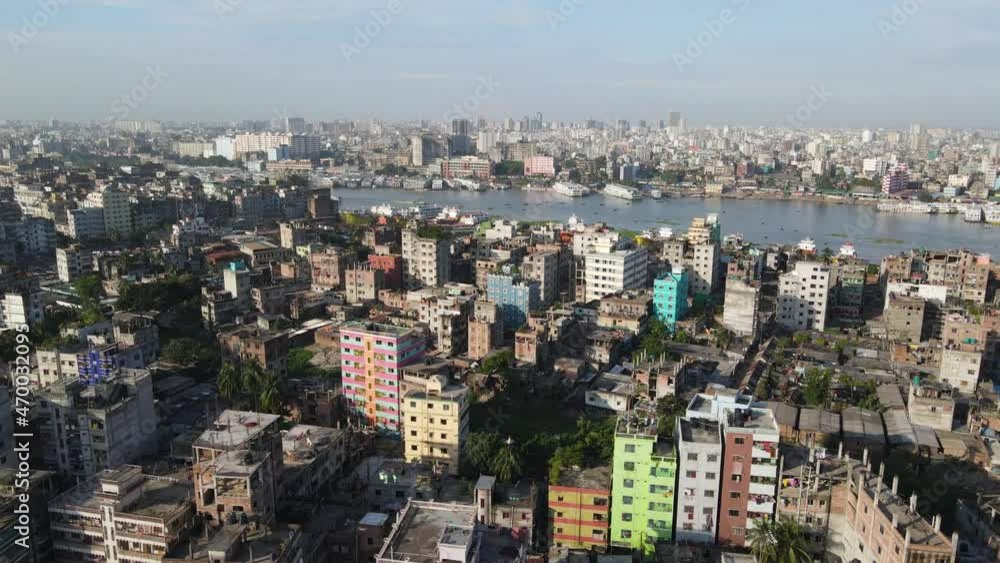 Aerial flight over populous city of Dhaka; view of boat traffic on Buriganga river - drone flight forward Aerial flight over populous city of Dhaka; view of boat traffic on Buriganga river - drone flight forward