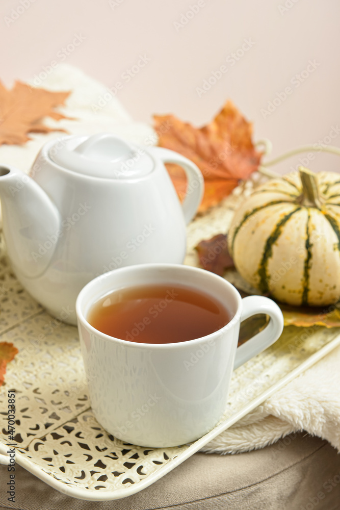 Tray with cup of tea on table near beige wall Tray with cup of tea on table near beige wall