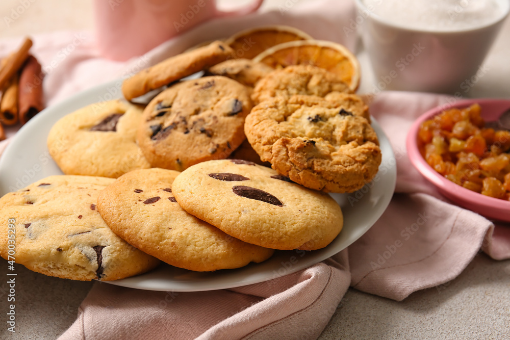Plate of tasty homemade cookies with chocolate chips on white background