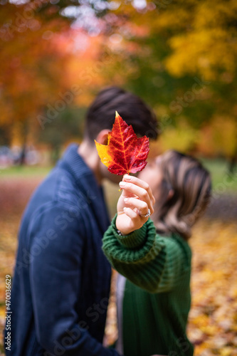 Couple kissing behind a leaf