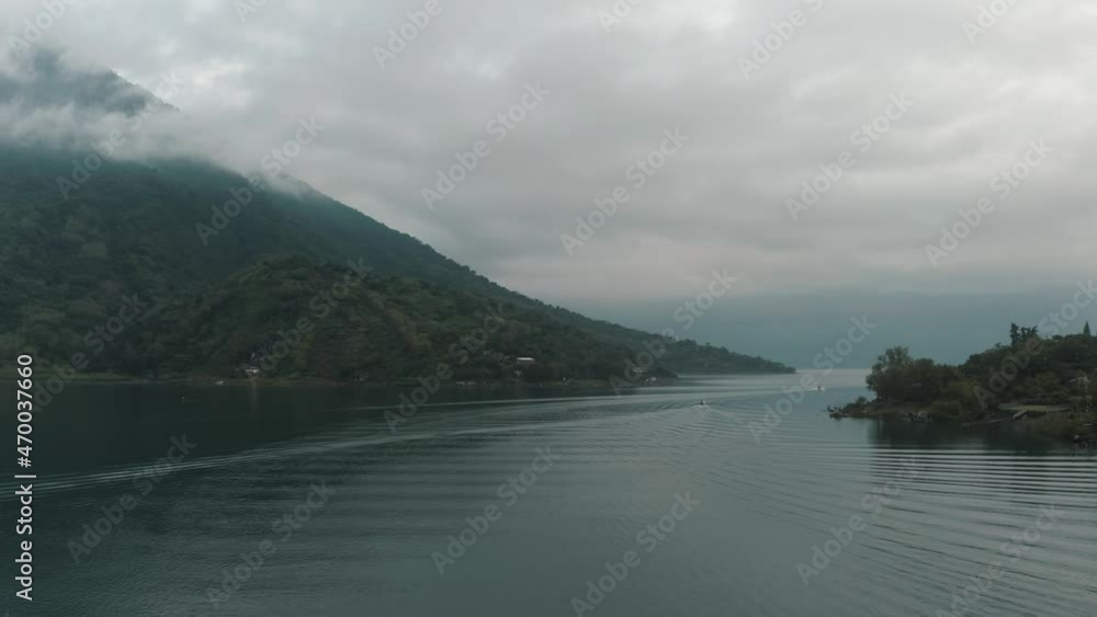 Boats Sailing On Serene Lake Of Atitlan With Santiago Volcano During Misty Sunrise In Guatemala. Aerial Drone