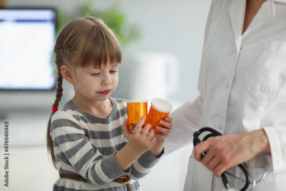 Child playing with bottles full of medication while on doctors appointment Child playing with bottles full of medication while on doctors appointment