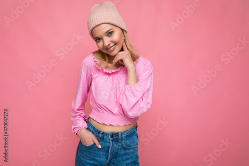 Beautiful positive happy young blonde woman isolated over colourful background wall wearing casual stylish clothes feeling sincere emotions looking at camera photo