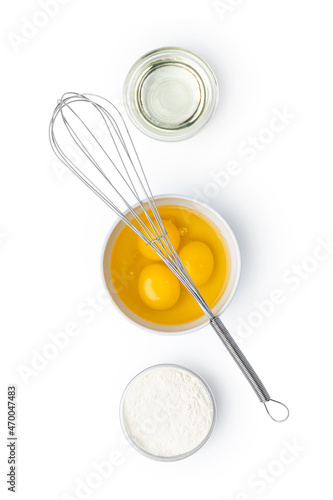 Metal whisk and eggs for cooking isolated on white
