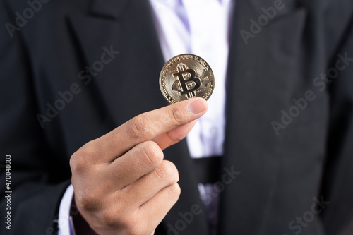 Businessman wearing a suit holding a bitcoin, bitcoin concept.