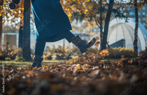 November and fun emotions. Autumn mood and inspiration. Young beautiful woman holding a transparent umbrella from which fall maple autumn leaves. Autumn concept.