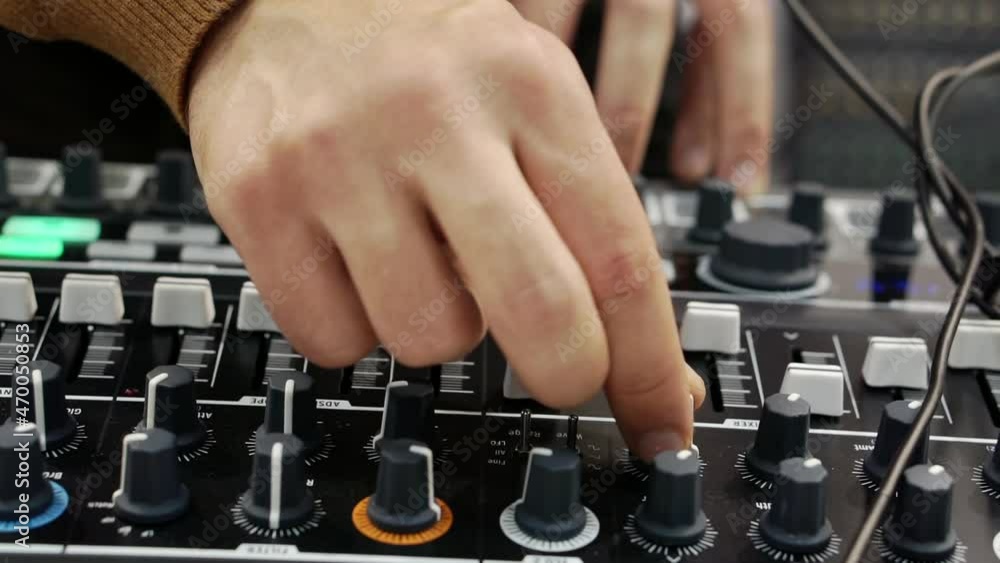 A person operates professional sound equipment. A person operates professional sound equipment.