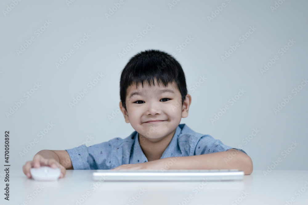 Child boy is using communicates on the Internet at home. homeschooling, distant learning, Asian little boy taking a class online and happy for Homeschool Quarantine Child boy is using communicates on the Internet at home. homeschooling, distant learning, Asian little boy taking a class online and happy for Homeschool Quarantine