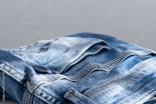 a blue light jeans on a grey background. Close up. Sunlight (ID: 470053862)